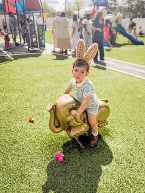 Child with Easter bunny ears on playground