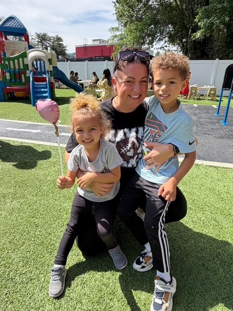 Parent with two children on the playground at a St. Peter's Academy event