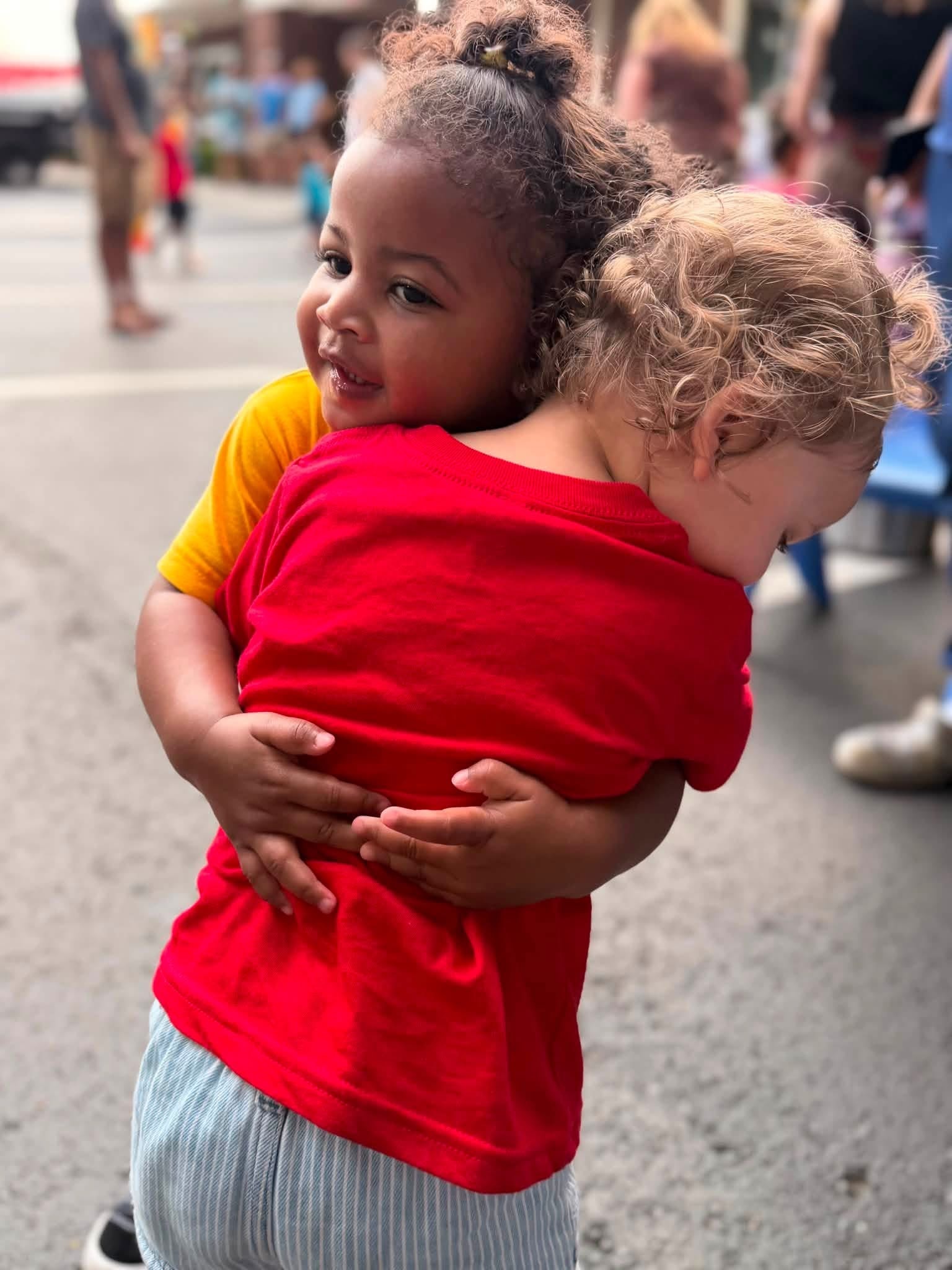 Two toddlers hugging each other at St. Peter's Academy